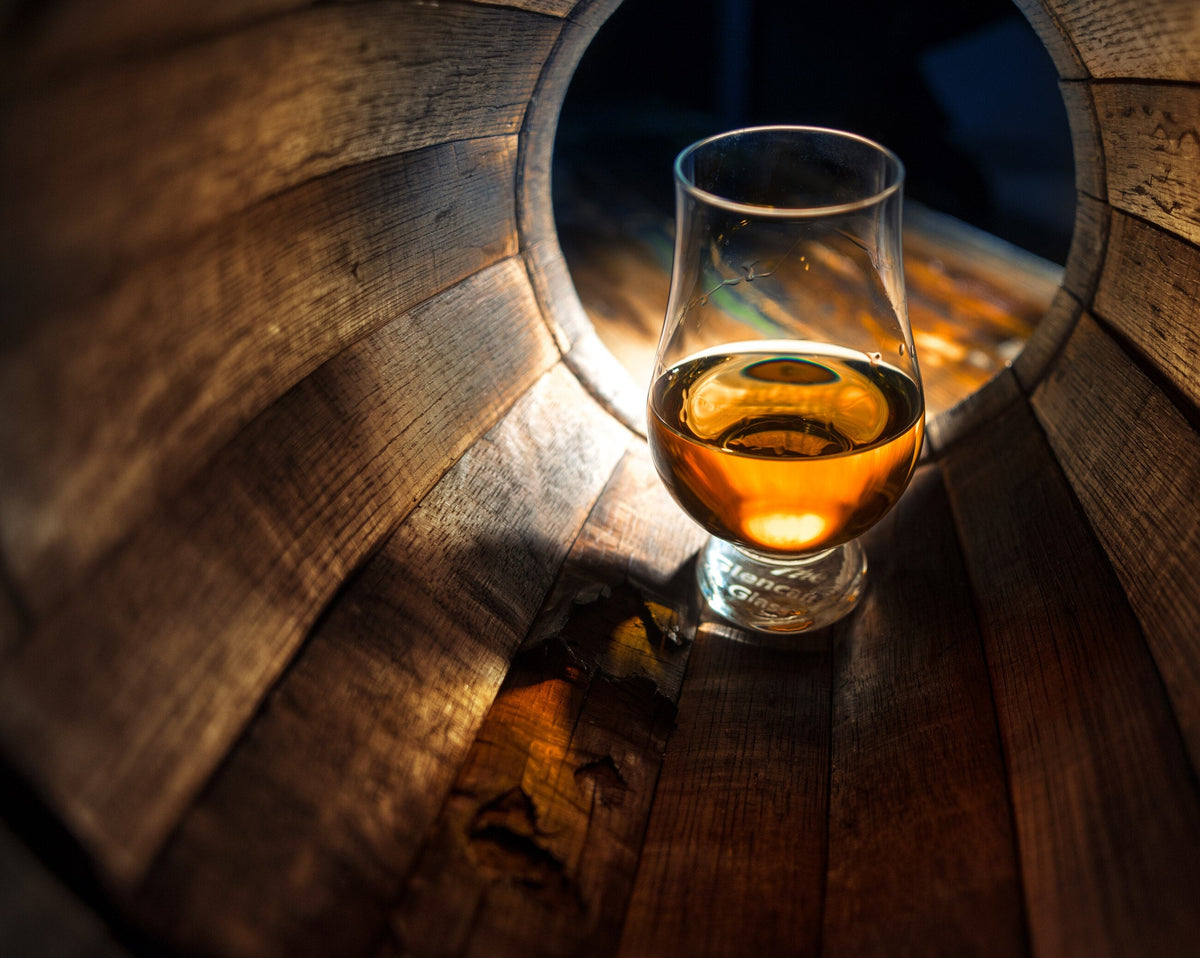 Whisky glass in a barrel